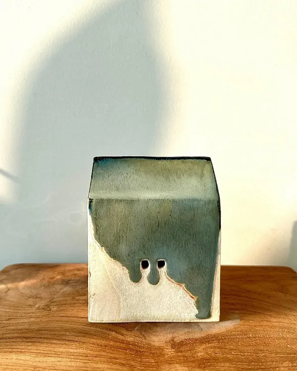 A miniature ceramic house with a beautiful green and white glaze. These small sculptures are a playful exploration of form and color.