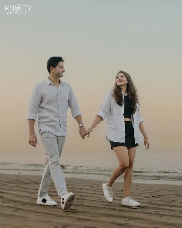 A classic pre-wedding beach photo. Walking hand-in-hand along the shore as the sun sets, this is a timeless portrait of togetherness and the start of a new journey.