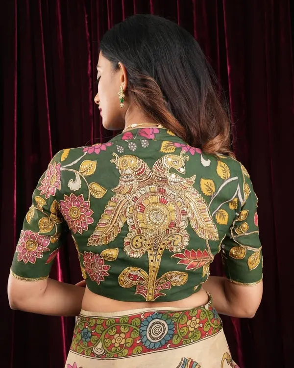 This is a piece I am incredibly proud of, a custom-stitched Pen Kalamkari blouse. The back features a stunning, hand-drawn peacock motif, making it a true work of wearable art. It's crafted from rich green fabric with elbow-length sleeves, perfect for pairing with a Kanjivaram or a simple cotton saree.