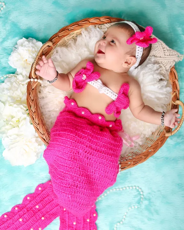 A dreamy mermaid-themed shoot for this happy baby. The hand-knitted pink mermaid tail and matching top create an adorable underwater fantasy.