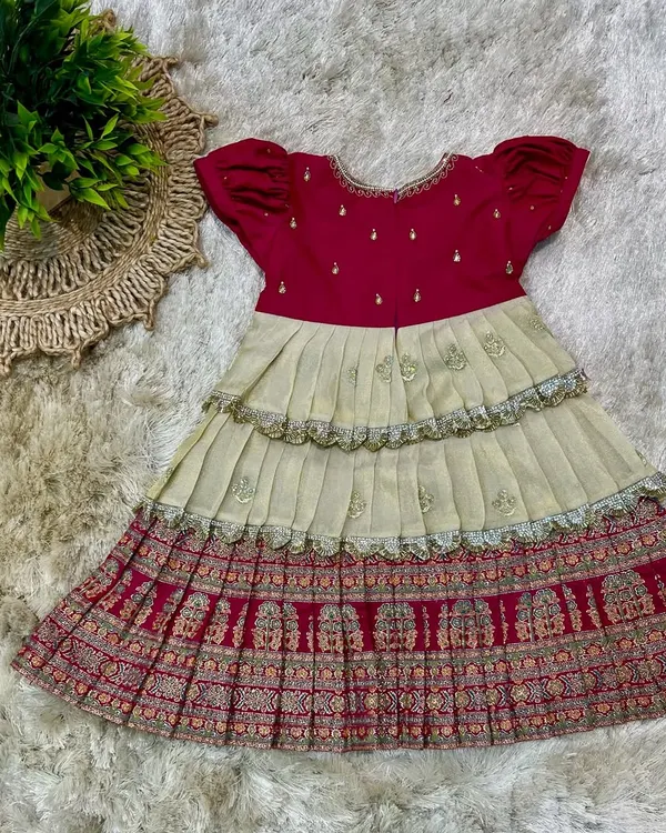 A custom-designed tiered frock for a little girl, using traditional printed fabric for the skirt and a simple magenta top.