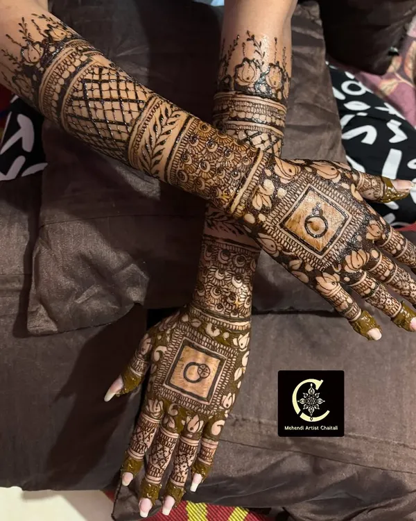 A classic engagement mehendi design featuring interlocking rings, a symbol of your commitment. The rest of the hands are filled with detailed traditional patterns.