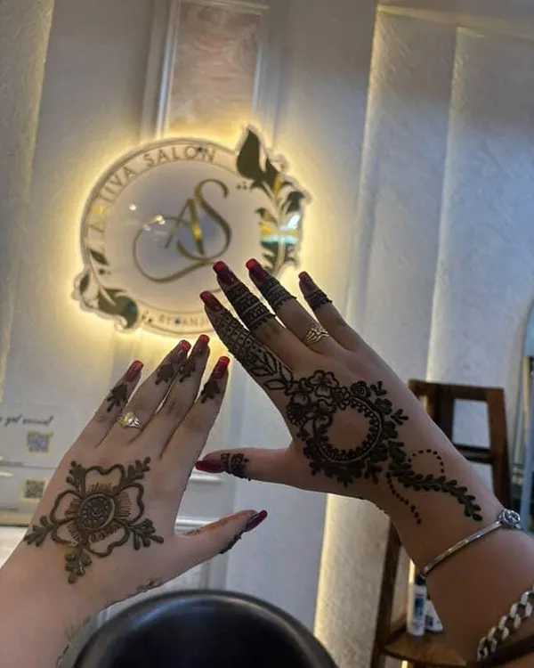 This photo shows two different mehendi styles perfect for an occasion like Rakhi. One hand features a delicate floral design on the back, while the other has a more intricate mandala and vine pattern, showing the variety I offer.