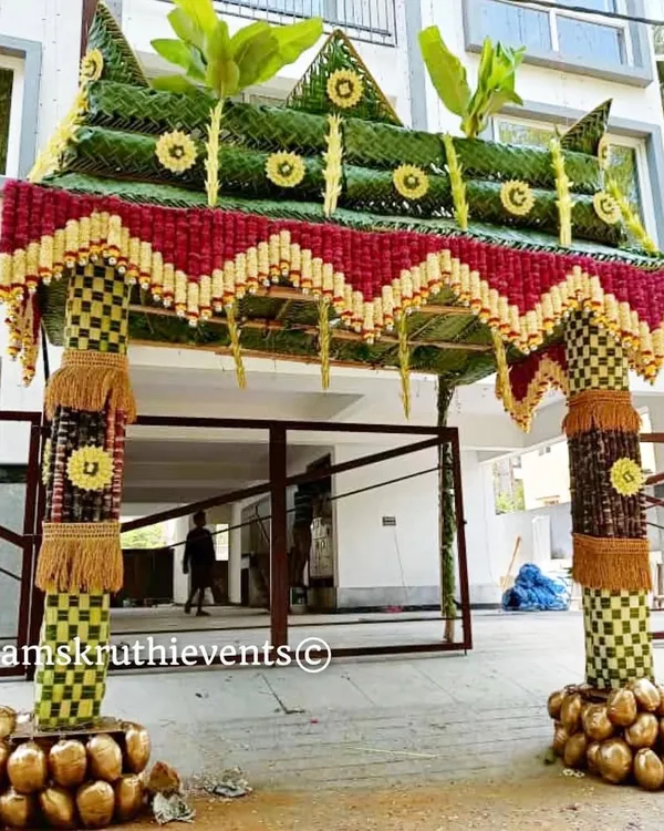 A magnificent 'Chappara' for a housewarming ceremony, made from woven coconut leaves and decorated with flowers. The base of the pillars is adorned with coconuts, symbolizing prosperity and new beginnings.