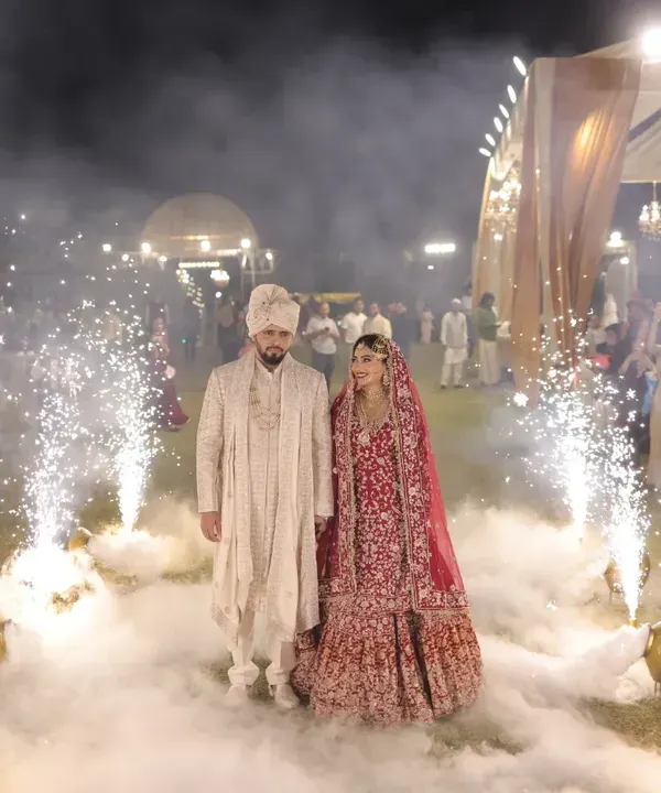 A grand entrance surrounded by cold pyrotechnics. This cinematic shot makes the couple's reception entry feel magical and unforgettable.