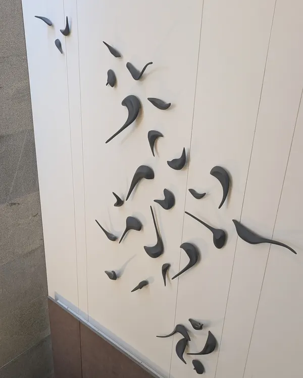 A close-up of the custom 3D bird sculpture from the 'Casa Vitals' project. Each bird is crafted and placed to create a sense of dynamic movement on the wall.