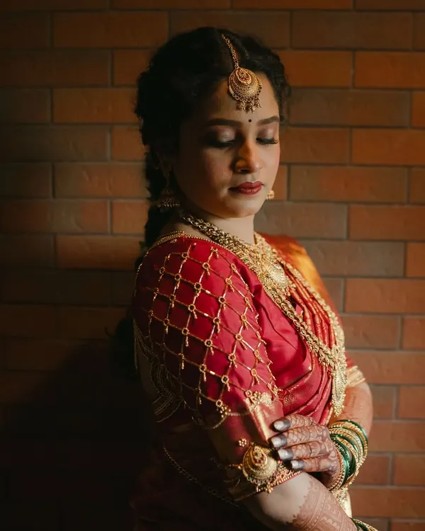 A classic South Indian bridal transformation. This portrait captures the regal feel, with a soft matte base, defined eyes, and a rich red lip to complement her silk saree.