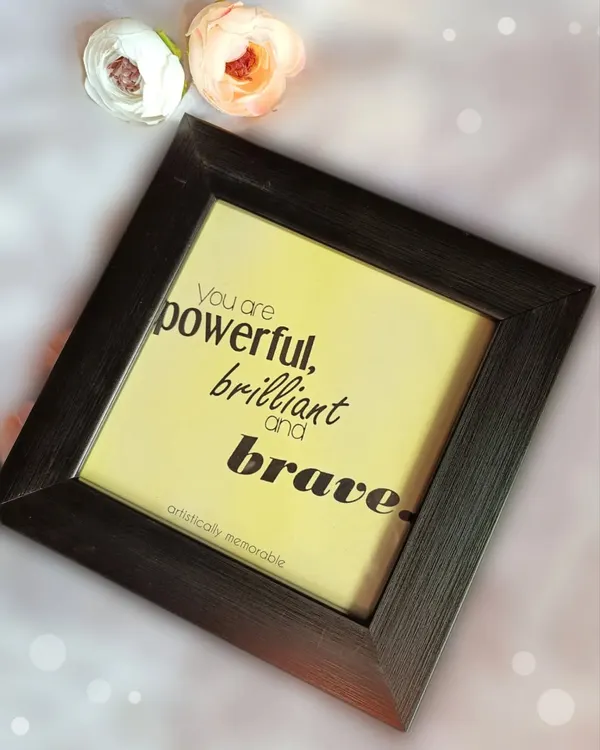 A mini quote frame with the empowering message, "You are powerful, brilliant and brave." This piece, set in a dark frame, is perfect for adding positivity to any workspace.