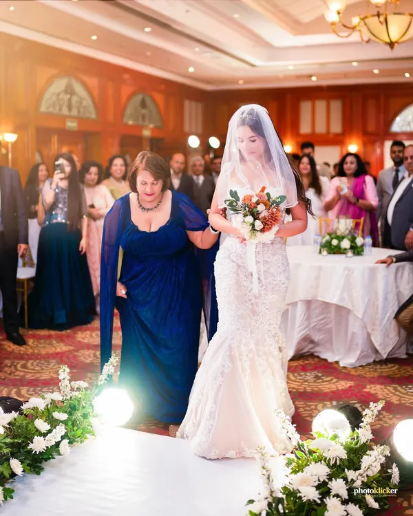 The bride's emotional walk down the aisle, escorted by her mother. A powerful moment from a beautiful Christian wedding ceremony at Jaypee Hotels.