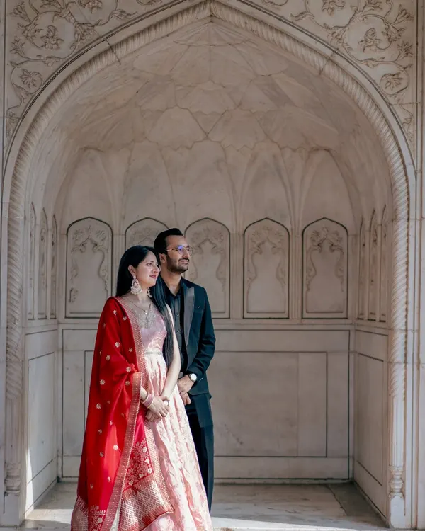 Standing within the intricate marble archways of a historic monument, this portrait feels both grand and personal. It’s a perfect example of a destination photoshoot that honors India's heritage.