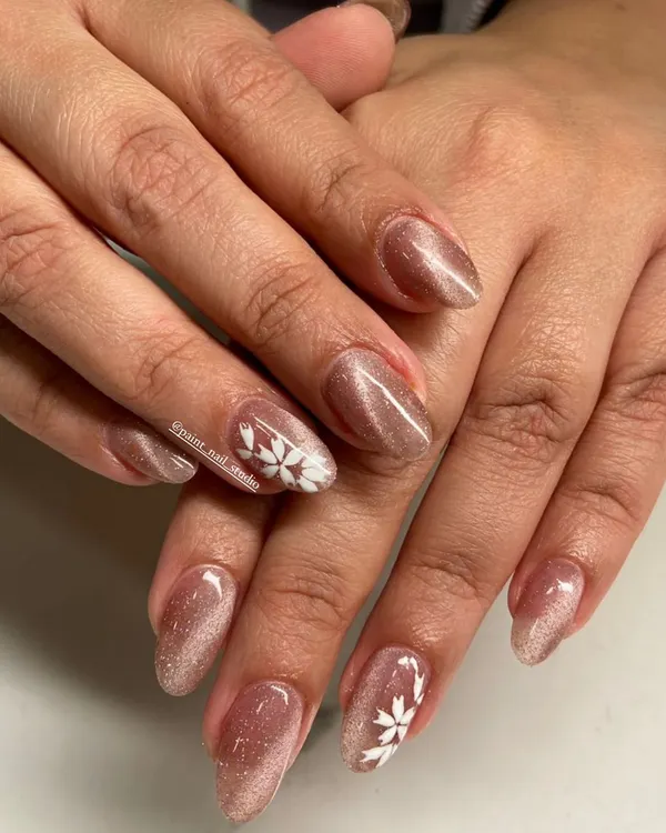Proof that short nails can be incredibly pretty. This design features a shimmery cat-eye gel polish with a delicate, hand-painted white snowflake accent.