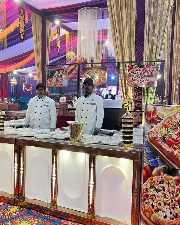 A dedicated live pizza station is a fantastic way to delight guests of all ages. My chefs are seen here in professional uniforms, ready to bake fresh pizzas with a variety of toppings, bringing a fun, international flavor to the wedding menu.