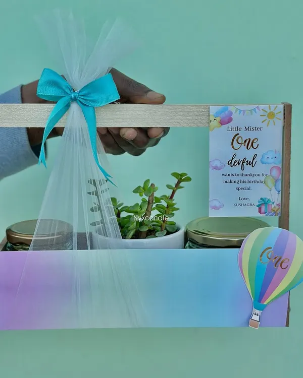 This pastel rainbow-themed hamper for a first birthday is one of my favorite creations. It includes a beautiful succulent plant and two jars of treats, all brought together with custom tags and a delicate net wrapping, showing how we tailor every detail to your theme.
