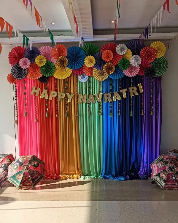 We specialize in bringing vibrant and unique themes to life for corporate celebrations. This colorful backdrop was the centerpiece for a corporate Navratri night, featuring rainbow drapes, paper fan decorations, and traditional umbrellas to create a festive atmosphere.