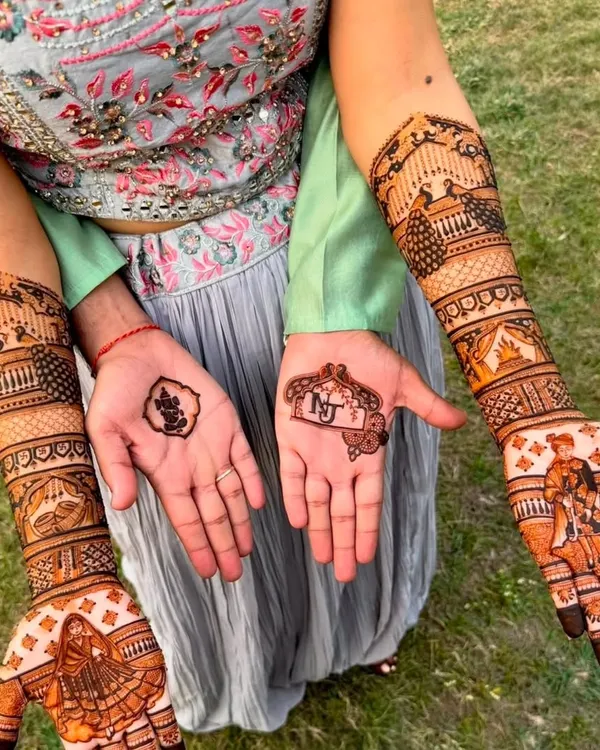 A masterpiece of storytelling henna. This full bridal design includes a bride in her doli, a groom on a horse, a Ganesh motif, and the couple's initials, creating a unique and personal work of art.