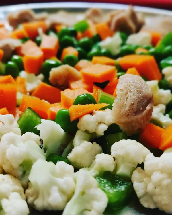 A colorful mix of fresh vegetables like carrots, peas, cauliflower, and soya chunks, ready to be made into Maharaja Poha.