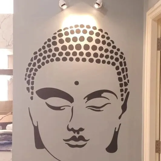 A minimalist Buddha face stencil, perfectly centered and highlighted by a spotlight, creating a tranquil and modern spiritual focal point.
