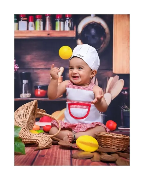 This little chef is cooking up some fun, tossing a lemon with the biggest smile. I love capturing these spontaneous, action-filled moments that show off your baby's playful personality in my creative themed shoots.