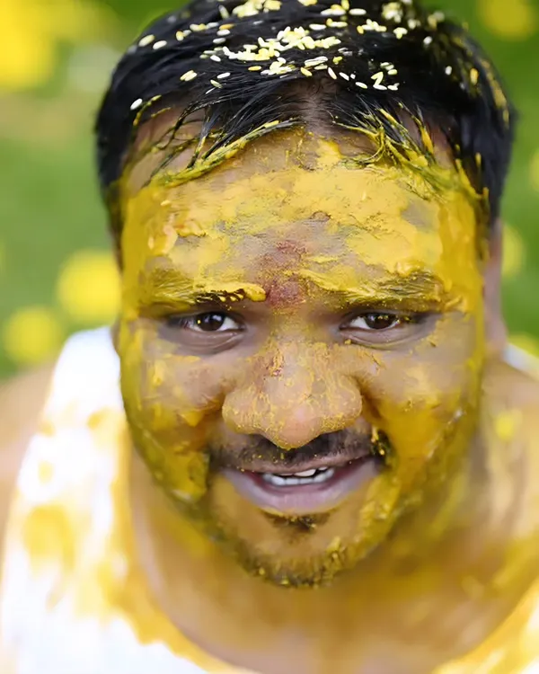 A close-up of the groom during his Haldi ceremony. We love capturing the fun and messy moments that make this ritual so memorable. His expression is a perfect mix of surprise and joy.