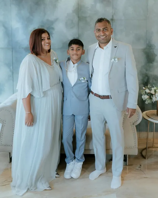 A beautiful family portrait in coordinated pastel tones. I designed the mother's flowing gown and the son's light blue suit to create a harmonious and picture-perfect look.