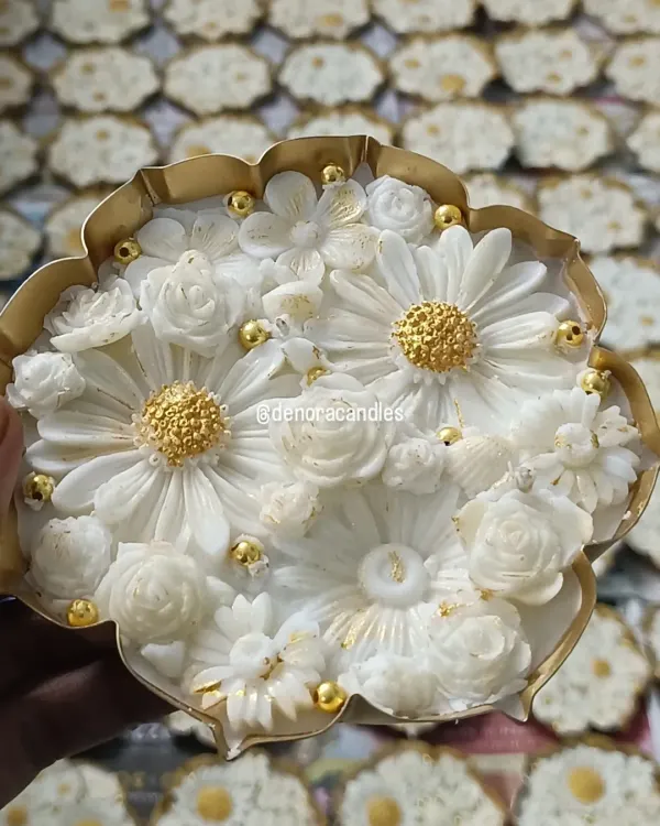 This is one of my signature pieces, a handcrafted lotus urli candle. I meticulously place each floral element into the natural soy wax and finish it with delicate golden details, making it a luxurious centerpiece for any festive occasion.