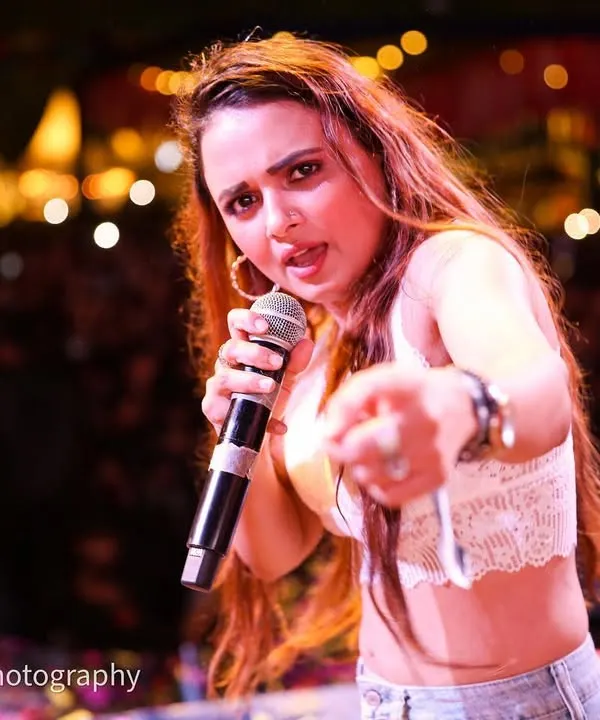 Shaheen Salmani of the band Rocknaama pointing right at the lens, connecting with the audience. I get right in the action to capture these interactive and engaging moments during live band performances.