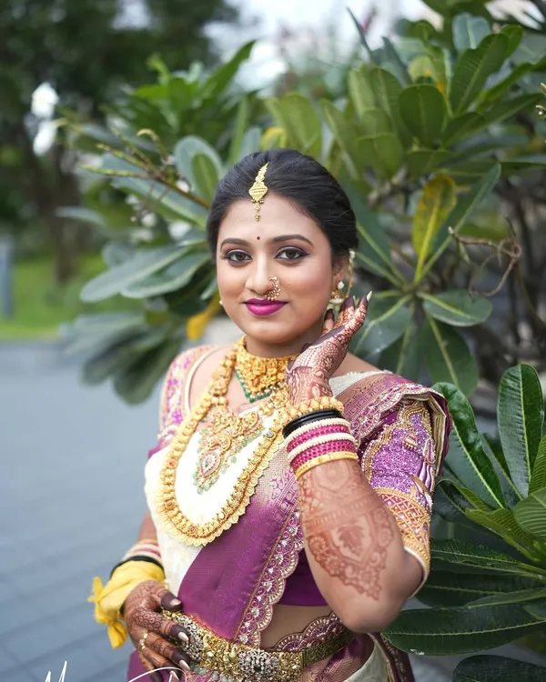 A beautiful portrait of Pooja on her wedding day. Her traditional South Indian bridal look features a classic updo, gold jewelry, and radiant makeup that enhances her natural glow.