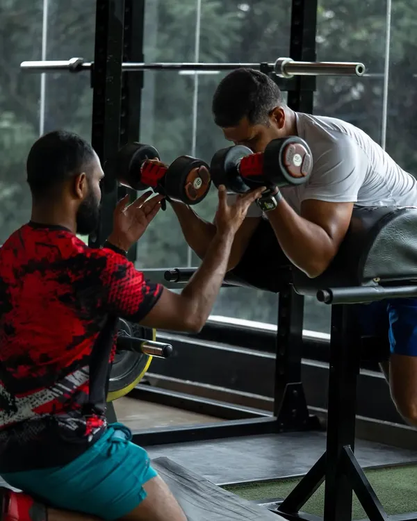 Perfecting your form is key to getting stronger and avoiding injury. I provide hands-on spotting and guidance for every exercise, like this dumbbell curl, to ensure you get the most out of every rep safely.