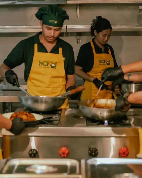 My team and I working together in the kitchen. We cook in traditional woks over high heat to get that authentic flavour.