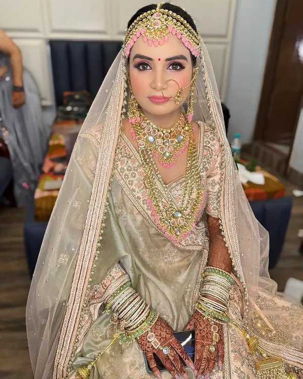A closer look at this beautiful pastel bride. The makeup is soft and romantic, with a focus on luminous skin, a hint of pink on the eyes, and a natural lip color to complement her unique floral jewellery.