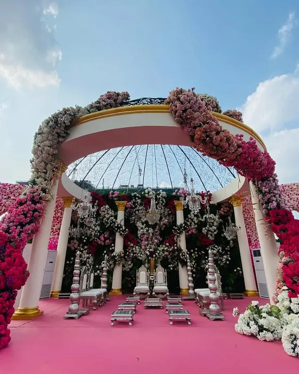 This is what I call a 'Gulabi Shaam' or a pink evening. I designed this magnificent dome mandap as a blossoming symphony of florals, creating a sacred space that is both grand and deeply romantic. The sheer scale and density of the flowers create an unforgettable, immersive experience for the couple and their guests.
