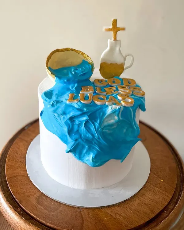 A special cake for a Holy Communion. The client requested a whipped cream cake with minimal fondant, so I created this design with a "waterfall" of blue cream and gold fondant accents.