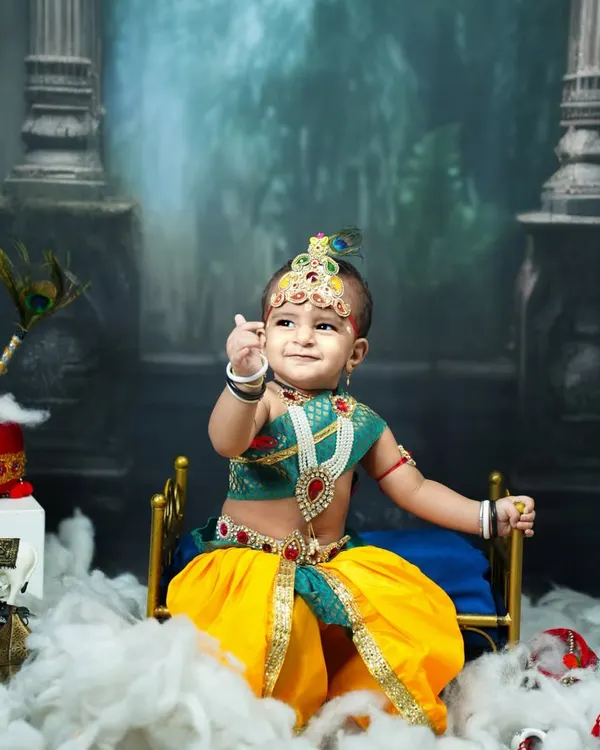 Our little Kanha in a classic pose. This image showcases the full Krishna setup with a divine backdrop, a pot of makhan, and the baby's playful expression.