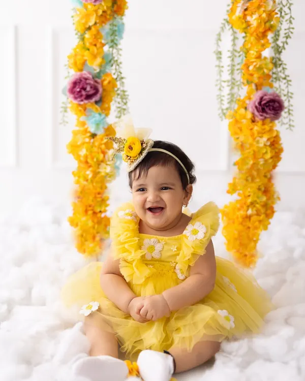 The happiest birthday girl! Her infectious laugh is the centerpiece of this sunny, floral-themed first birthday photoshoot.