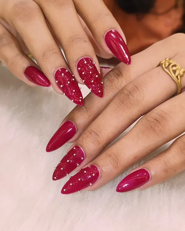 These nails are not for the faint of heart. This fierce stiletto set features a glossy, deep red color with accent nails that have a textured, beaded design for a look that's both dangerous and beautiful.