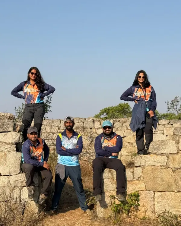 A corporate team posing on ancient fort walls during a morning trek. We organized this outing to celebrate Women's Day, combining adventure with team unity.