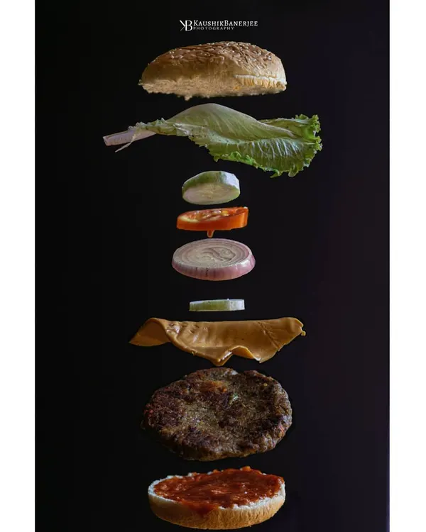 A deconstructed gourmet burger, captured mid-air. This levitation shot is a perfect example of how I blend technical precision with creative imagination to make every ingredient the hero.