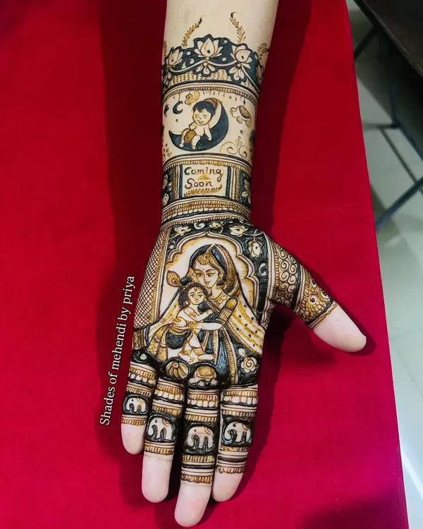 A complete baby shower mehendi design. The palm features a loving portrait of a mother and child, with a 'Coming Soon' message and a baby in a crescent moon on the arm.
