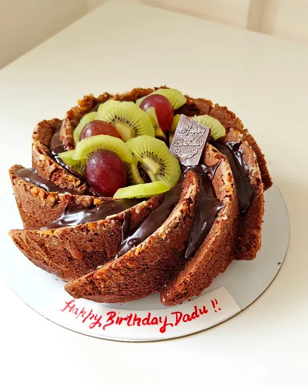 This is a perfect example of my wholesome baking, a whole wheat Bundt cake made for a birthday. It's topped with a rich chocolate ganache, fresh kiwi, and grapes, proving that healthy can be celebratory and delicious.