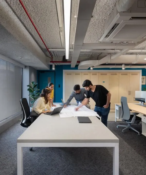 Collaboration is at the heart of our design process and the offices we create. This image shows a typical scene in a modern workspace we designed, with an open layout and large tables that encourage teamwork.