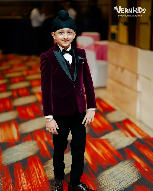 A picture of pure elegance. This young gentleman is ready for a wedding reception in our made-to-measure velvet tuxedo, featuring a satin lapel and a perfect fit that exudes class.