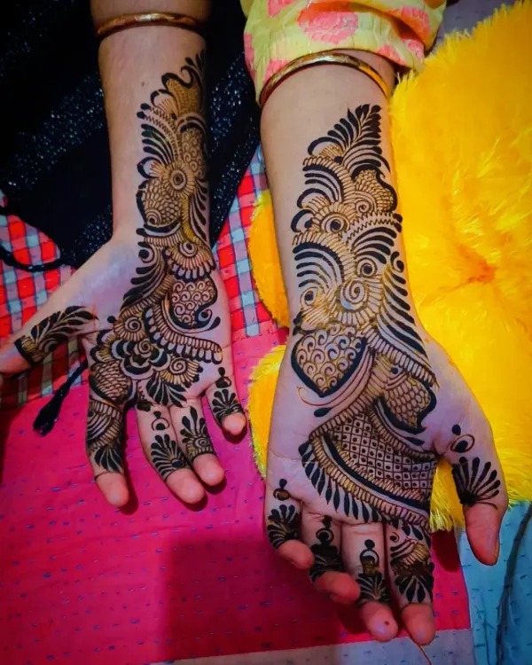 A bold and beautiful Arabic mehandi design. This style is characterized by thick, dark outlines and flowing patterns that create a striking look on the back of the hand.