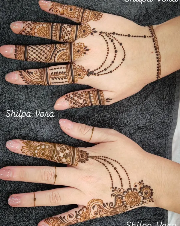 A beautiful example of a modern fusion design, combining detailed finger work with a delicate 'hathphool' (hand jewelry) style pattern on the back of the hand.