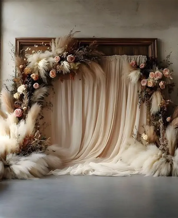 This dreamy boho backdrop is crafted with soft, flowing fabric and an arch of pampas grass and dried florals. It provides a romantic and textural background ideal for a ring ceremony or bridal shower.