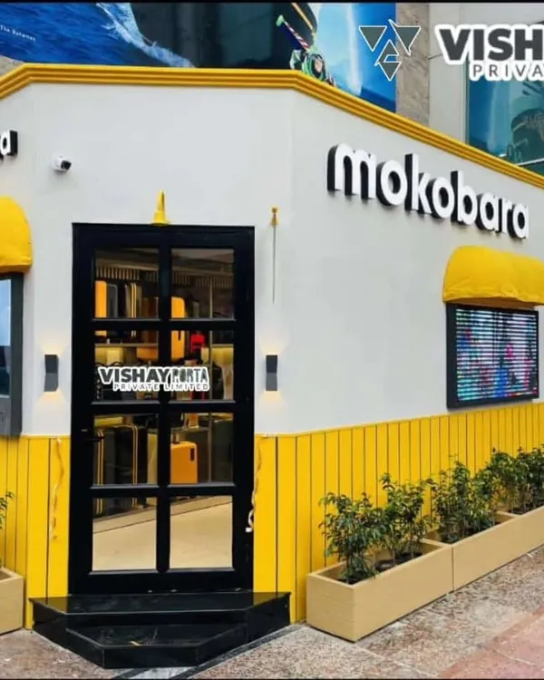 This is the finished Mokobara pop-up store in Gurugram, a project I'm very proud of. Notice the bright yellow paneling, backlit 3D logos, and warm exterior lighting that make it inviting for evening shoppers. This is a prime example of a high-impact portable retail solution.
