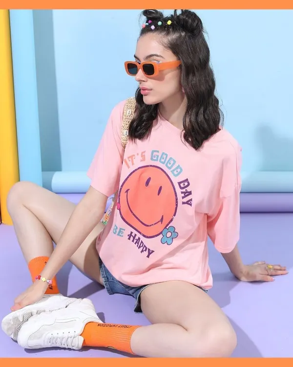 For this Tokyo Talkies shoot, I created a happy, carefree vibe with a pink graphic tee and denim shorts. The colorful background and playful accessories complete this youthful, Gen-Z look.