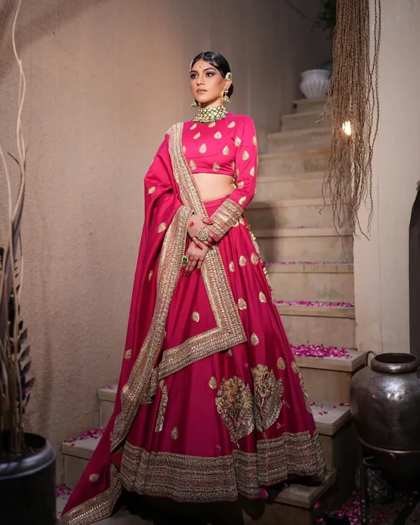 A stunning fuchsia pink lehenga styled for a festive look. I paired it with traditional Kundan jewelry and a sleek bun adorned with a red rose for a touch of classic romance.