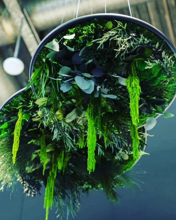 This is a custom-made hanging installation filled with various types of artificial greenery. These "floating islands" are suspended from the ceiling and serve as a unique centerpiece for a large room.
