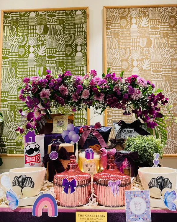 A housewarming gift designed to make a new space feel like home instantly. This hamper, in shades of mauve and purple, combines beauty and utility with a stunning fresh floral arrangement, elegant mugs, decorative jars, and comforting snacks. It’s a warm hug in a box, for when you can't be there in person.