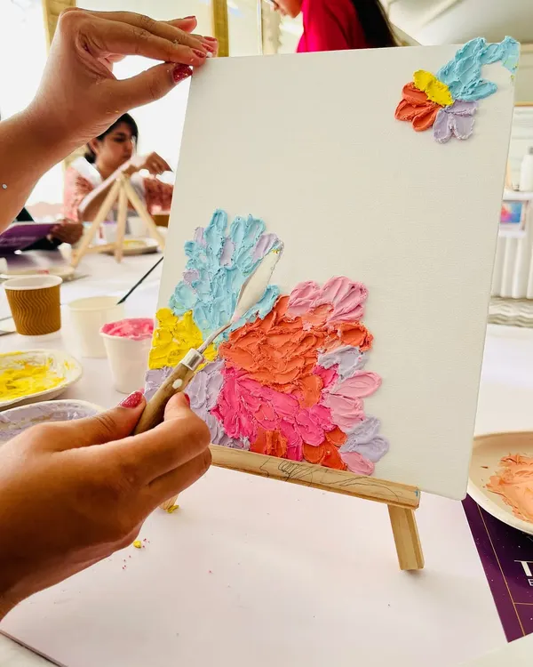 A close-up from one of our texture art experiences. Here, a participant is using a palette knife to create beautiful, pastel-themed floral textures on their canvas. I love seeing people discover their creativity.